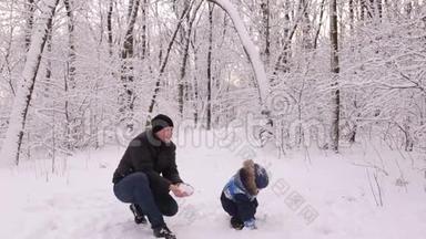 年轻的爸爸和他的小儿子在玩雪
